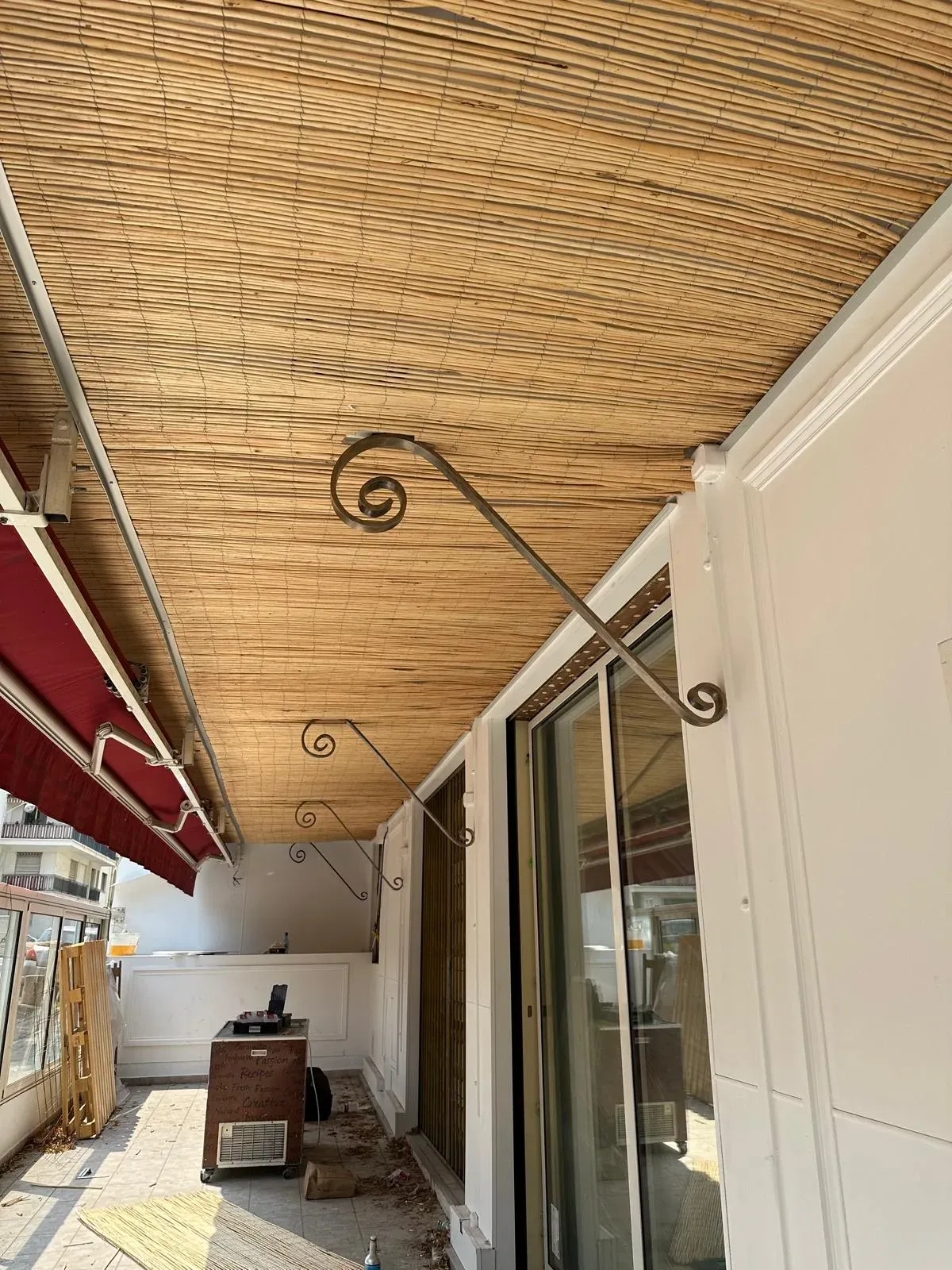 Canisse en bambou posée au plafond d'un balcon couvert